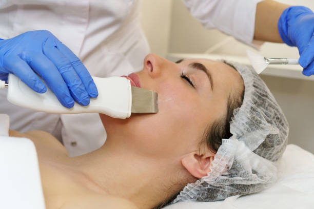 Woman receiving ultrasound facial treatment in spa.