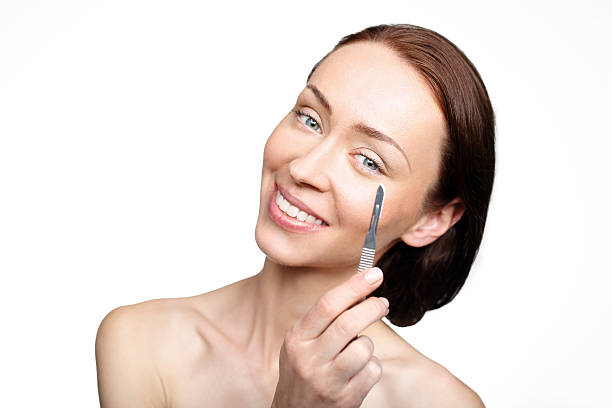 Smiling woman applying under-eye cream